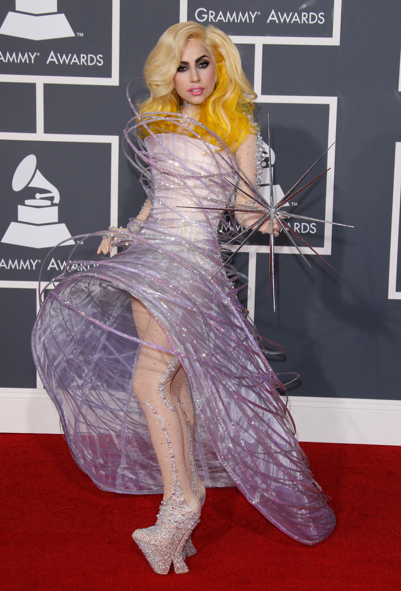Durante la era 
<i>Monster</i> de Lady Gaga, en el 2010, no había nada más emocionante y divertido para los fans de la entonces ascendente artista que mirar cada una de sus extravagantes apariciones en alfombras rojas. La de los Grammy en ese año no fue la excepción y lució un look espacial de Armani Prive y esculturales plataformas.