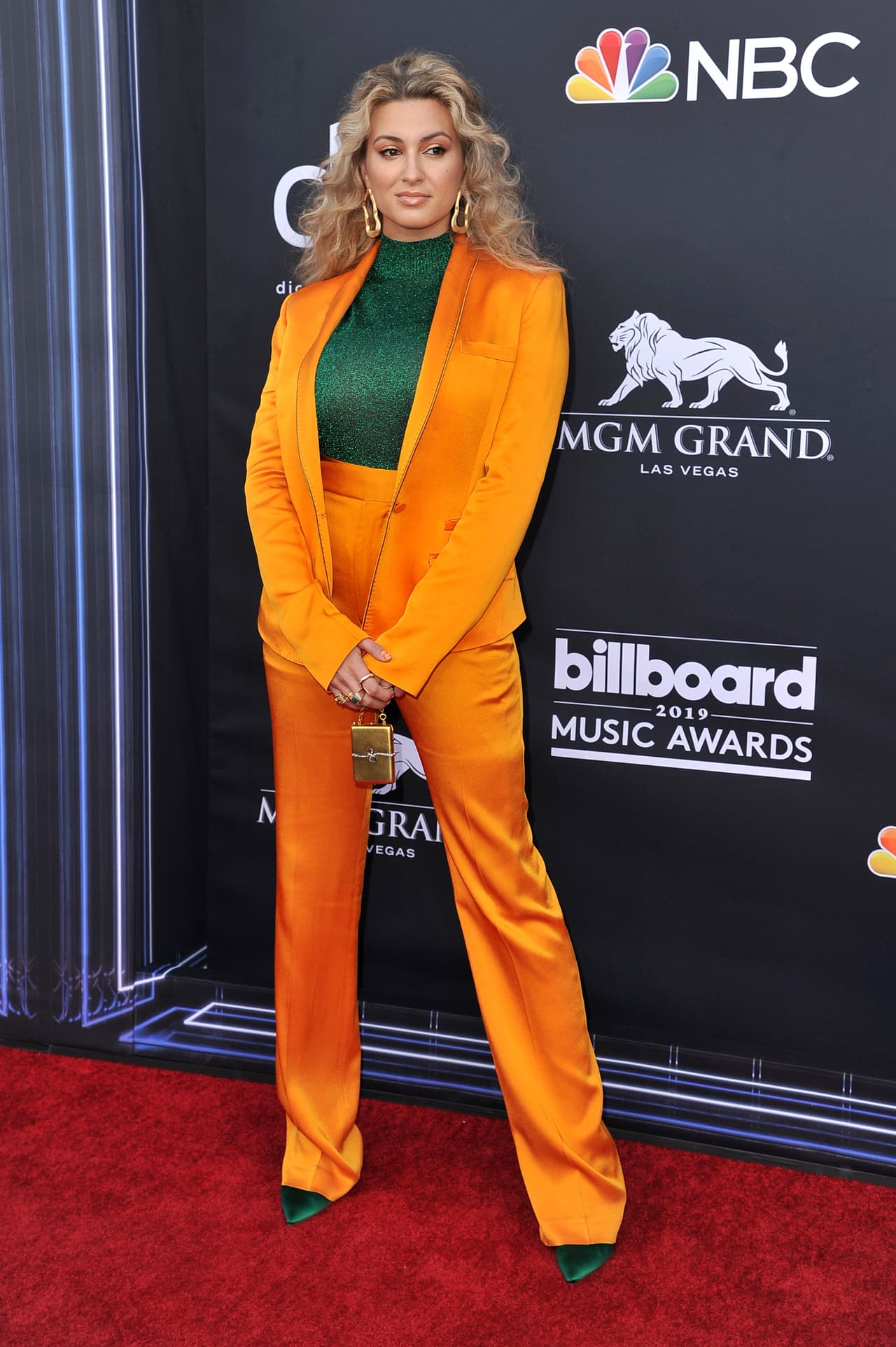 La cantante Tori Kelly brilló de pies a cabeza. Empezando por sus aretes dorados que combinó con un traje naranja. Su blusa y sus zapatos del mismo tono verde esmeralda, le dieron el toque perfecto a su 'look'.