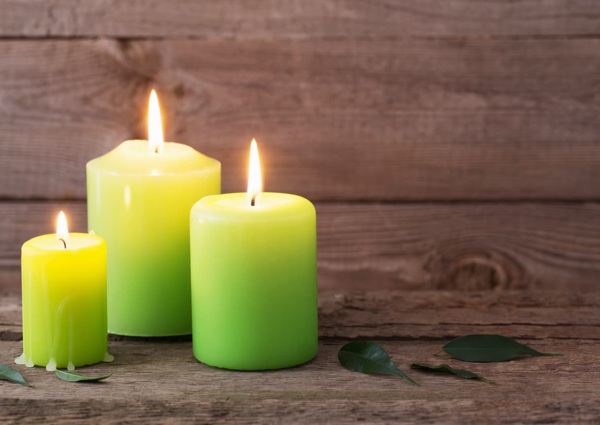 green candles on dark wooden background