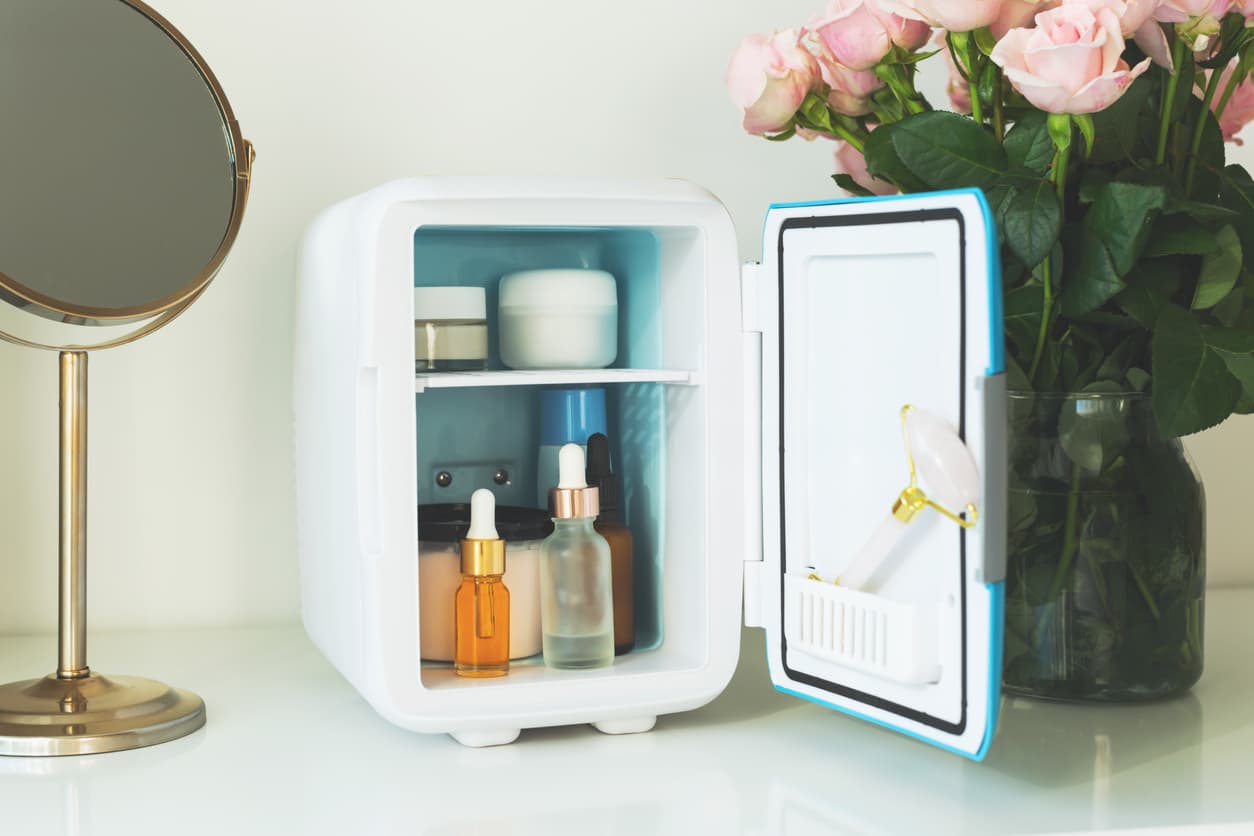 Mini fridge on the vanity table. Selfcare concept. Keep skincare, makeup and beauty product cool and fresh. Extend shelf live of creams, serums. Keep your beauty products organized and cool.