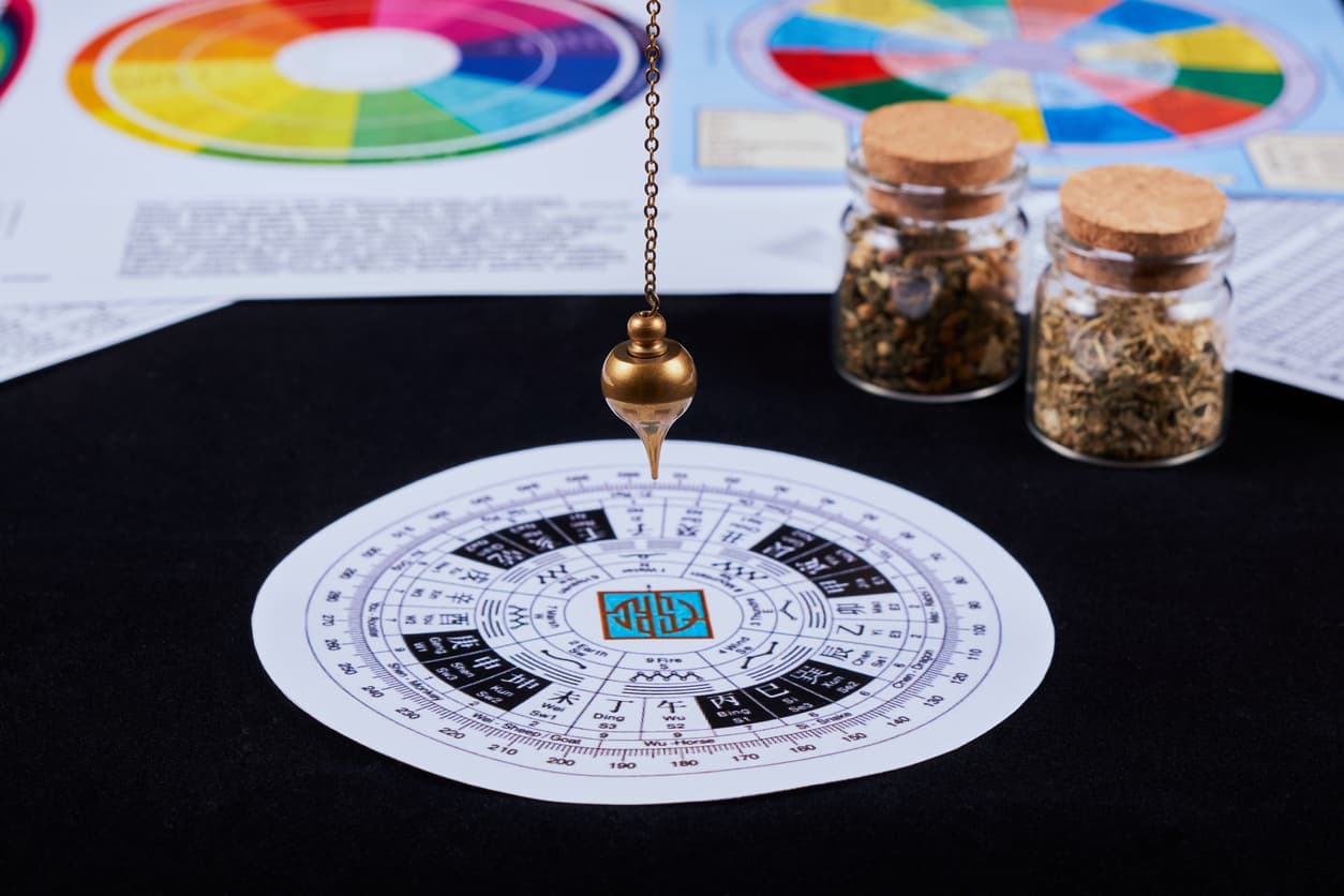 Astrological pendulum for tarot and astrological circle on the background of astrological charts, magical potions and astrological horoscopes