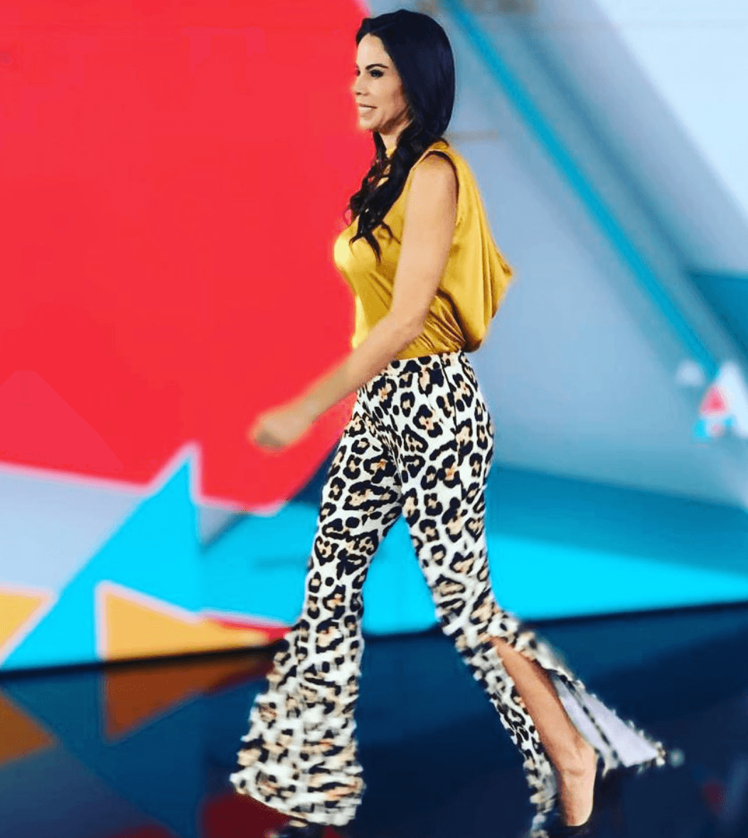 La periodista se robó las miradas con ese pantalón acampanado de 
<i>animal print</i>, el cual combinó con una blusa de satén en color mostaza sin mangas.