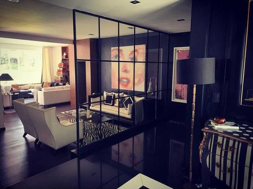 Su sala, que es de colores negro y blanco, tiene un estilo moderno, pues en la pared del espacio principal tiene colgado un gran cuadro de Marilyn Monroe, dándole un toque único.
<br>
<br>Su piso se puede notar que es de madera color nogal, manteniendo así el toque oscuro del hogar, haciéndolo lucir muy formal. 
<br>