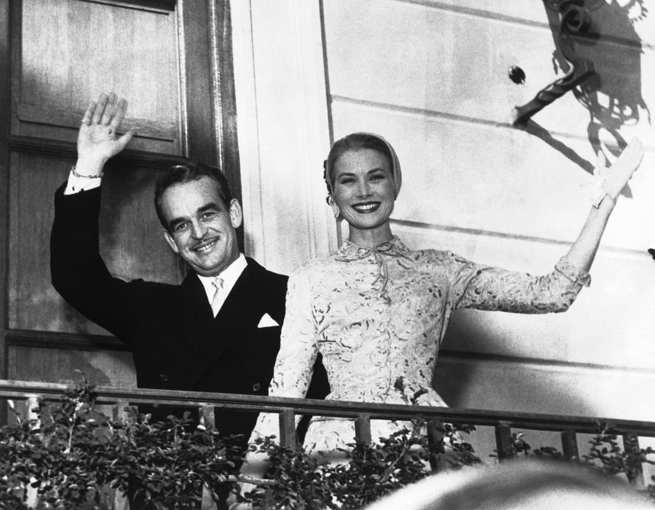 Grace Kelly and Prince Rainier wave to their guests from a balcony at the palace garden party following their civil wedding in Monaco, on April 18, 1956. (AP Photo)