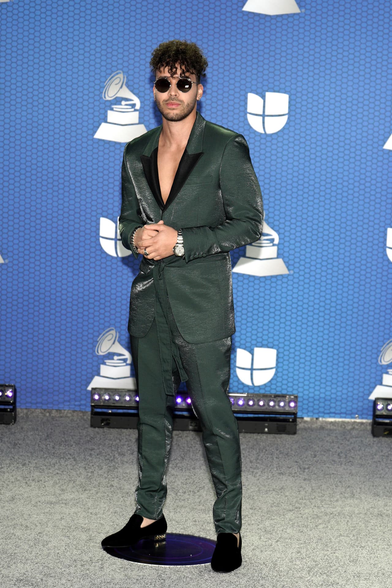 Prince Royce arribó a la gala con uniéndose a la tendencia de solapas con cuellos amplios o asimétricos. El cantante de bachata estilizó su look con un peinado con fleco de rizos, alborotando el frente de su rostro, reviviendo la década de los 80.