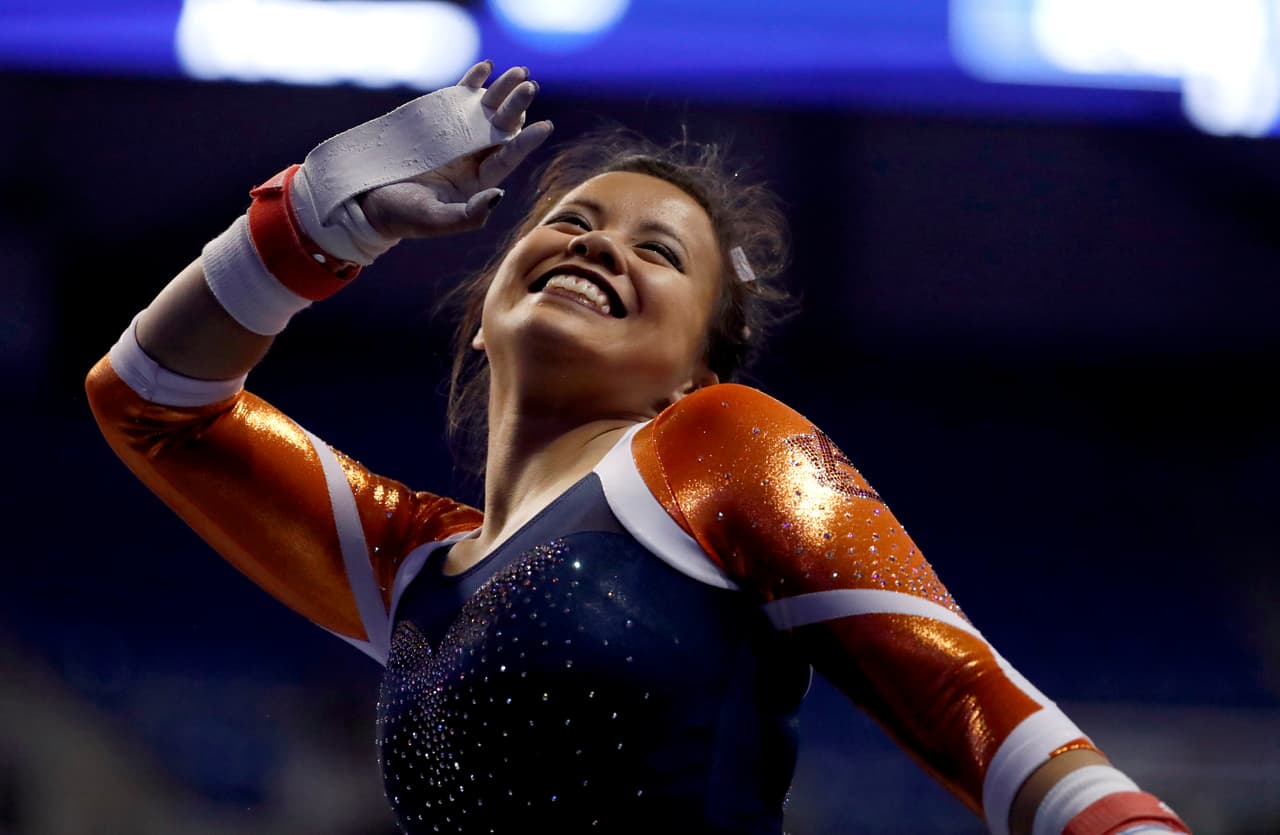 Auburn's Samantha Cerio smiles and signals to the crowd before competing on the uneven parallel bars during the NCAA women's gymnastics championships Friday, April 14, 2017, in St. Louis. (AP Photo/Jeff Roberson)