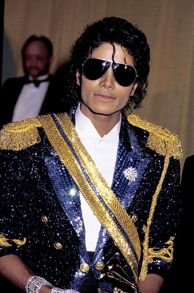 Sin duda, uno de los looks más icónicos en la carrera de Michael Jackson tuvo lugar en los premios Grammy de 1984, con el que no solo pudo brillar al máximo con su 
<i>blazer</i> militar de piedras brillantes, sino que fue el momento en el que volvió del guante solitario un elemento y sello personal de su estilo.