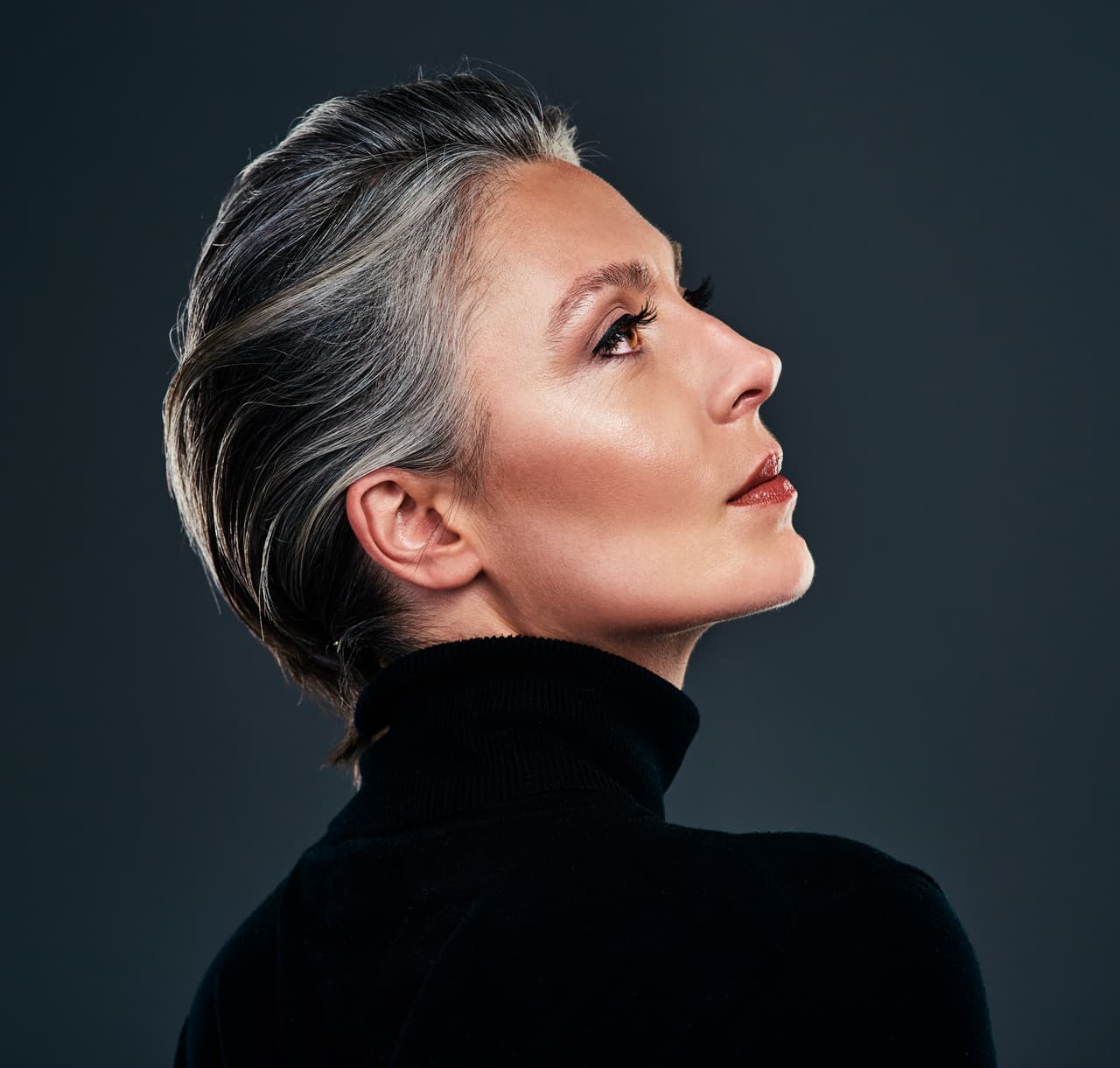 Studio shot of a beautiful mature woman posing against a dark background