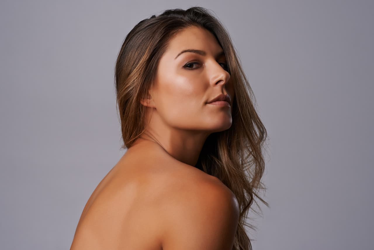 Studio shot of a beautiful young woman posing against a gray background