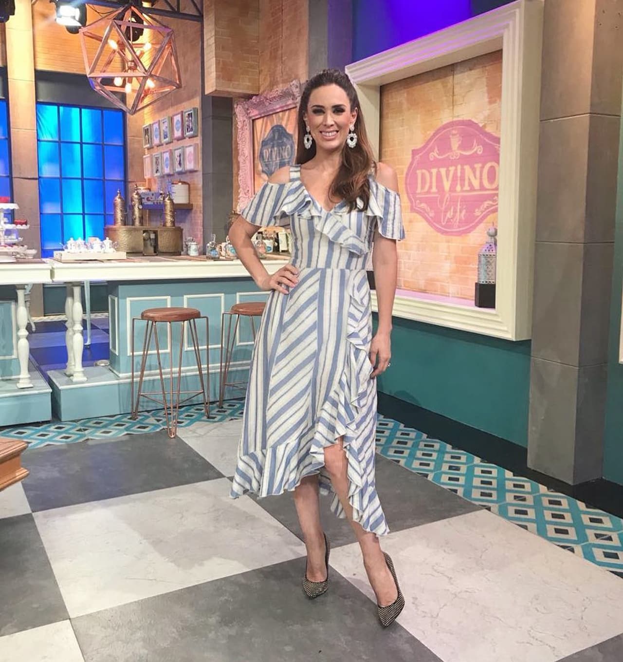 Para uno de sus primeros looks como conductora del programa, en el 2018, Jacky Bracamontes lució un maxivestido en color blanco con líneas azules. La presentadora de televisión robo suspiros con aquel 
<b>estilo primaveral</b>, el cual accesorizó con grandes aretes y dejó su cabello recojido en media coleta.