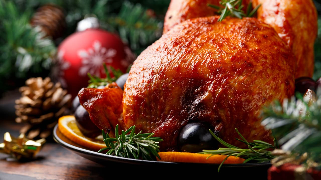 Christmas Chicken, roast in oven with decoration, gifts, green tree branch on wooden rustic table.