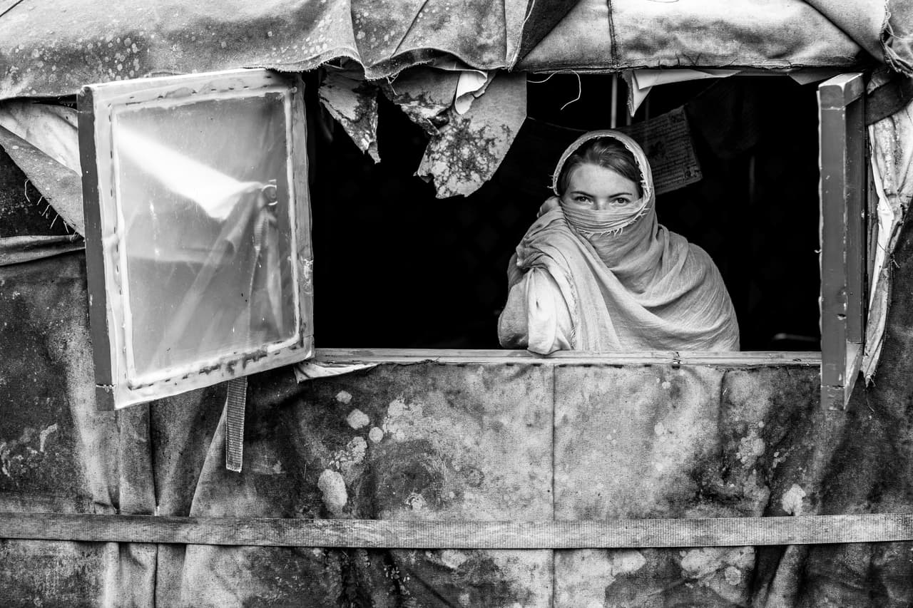 Young European girl in a nomad tent window. Black and white photography