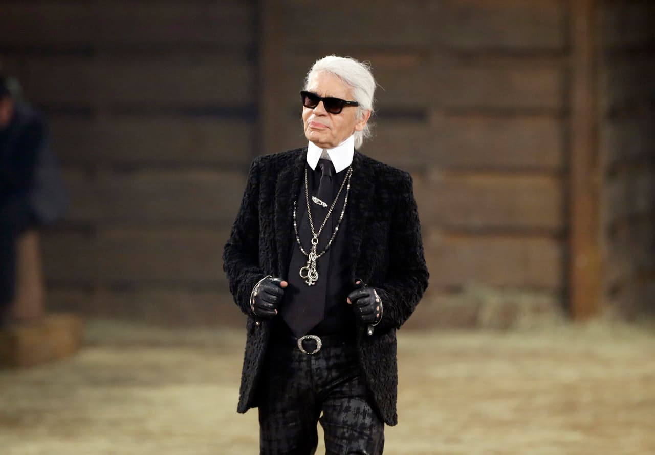 FILE - In this Tuesday, Dec. 10, 2013 file photo, Chanel designer Karl Lagerfeld takes a bow at the end of his Metiers d'Art fashion show, Tuesday, Dec. 10, 2013, in Dallas. Chanel's iconic couturier, Karl Lagerfeld, whose accomplished designs as well as trademark white ponytail, high starched collars and dark enigmatic glasses dominated high fashion for the last 50 years, has died. He was around 85 years old. (AP Photo/Tony Gutierrez, File)