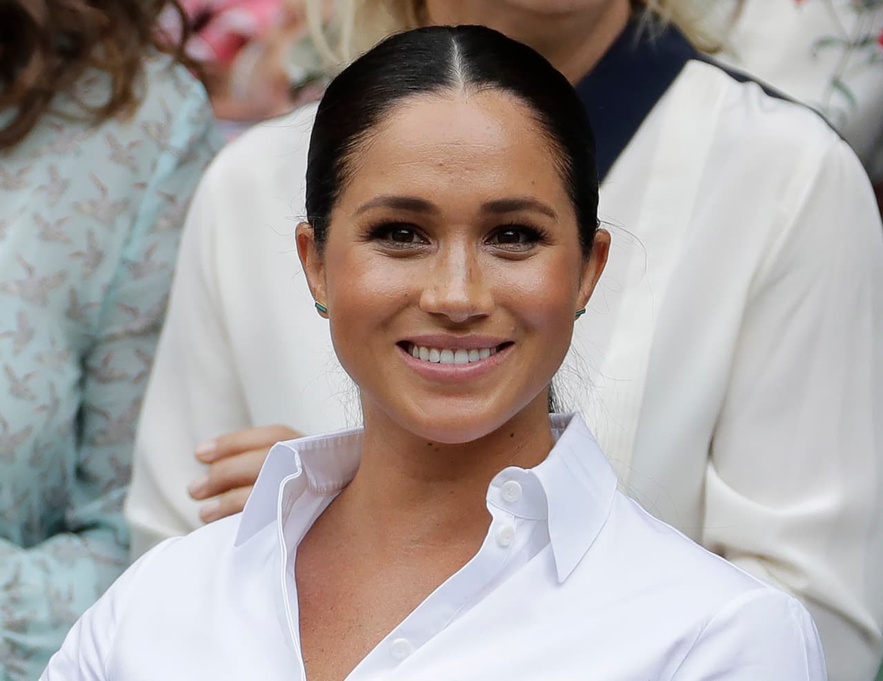 FILE - In this July 13, 2019 file photo, Kate, Meghan, Duchess of Sussex smiles while sitting in the Royal Box on Centre Court to watch the women's singles final match between Serena Williams, of the United States, and Romania's Simona Halep on at the Wimbledon Tennis Championships in London. Meghan has guest edited the September issue of British Vogue with the theme "Forces for Change." Royal officials say the issue coming out Aug. 2 features “change-makers united by their fearlessness in breaking barriers” and includes a conversation between Meghan and former U.S. first lady Michelle Obama. (AP Photo/Ben Curtis, File)