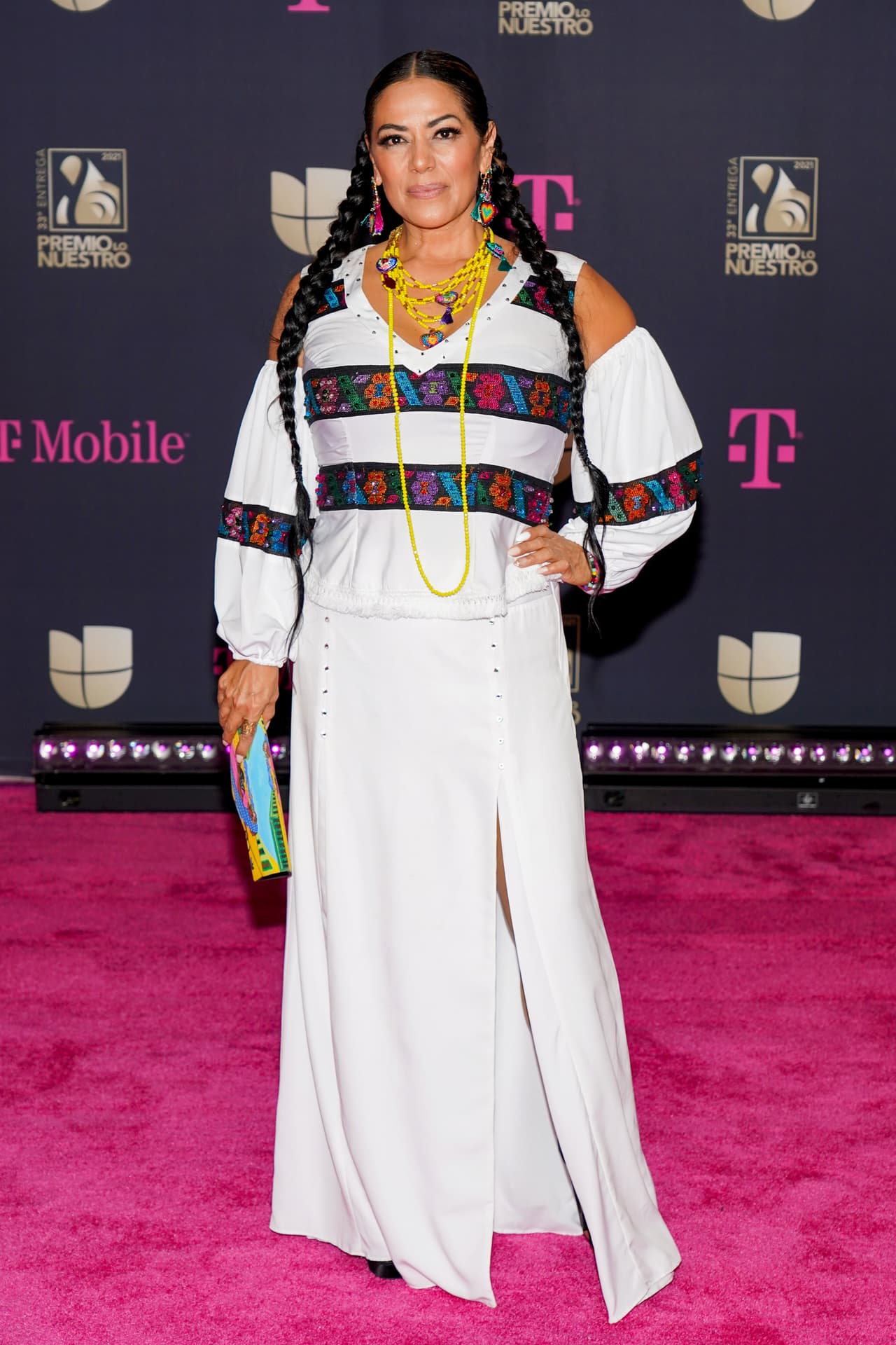 Lila Downs, respetando su gusto por los trajes con detalles tradicionales, llegó con un conjunto blanco con acentos bordados y collares coloridos a juego. Un par de trenzas y una bolsa llena de color fueron el complemento para su look.