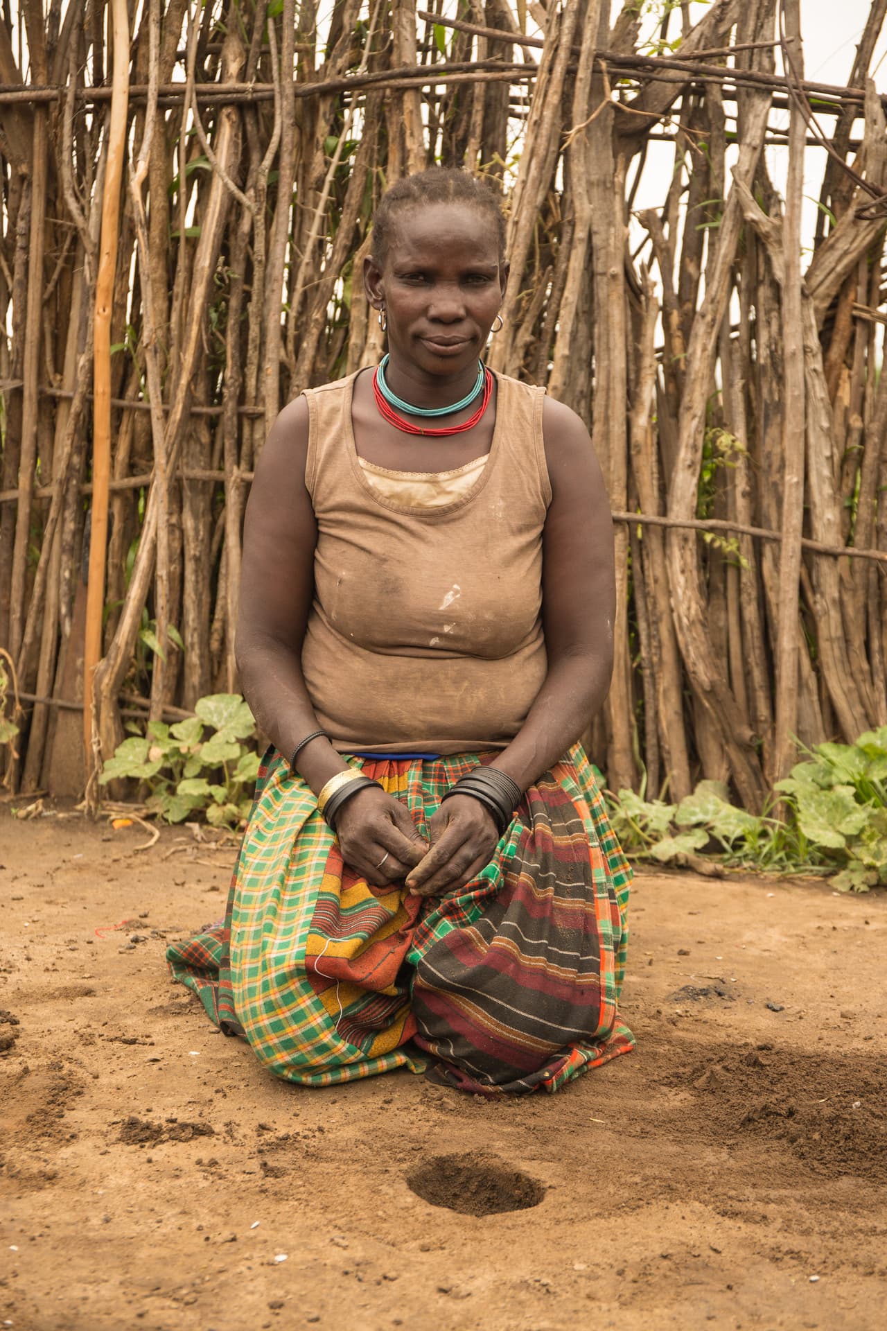 El período de: Munyes. Tiene 44 años, vive en Karamoja, Uganda y usa un pozo en el suelo.