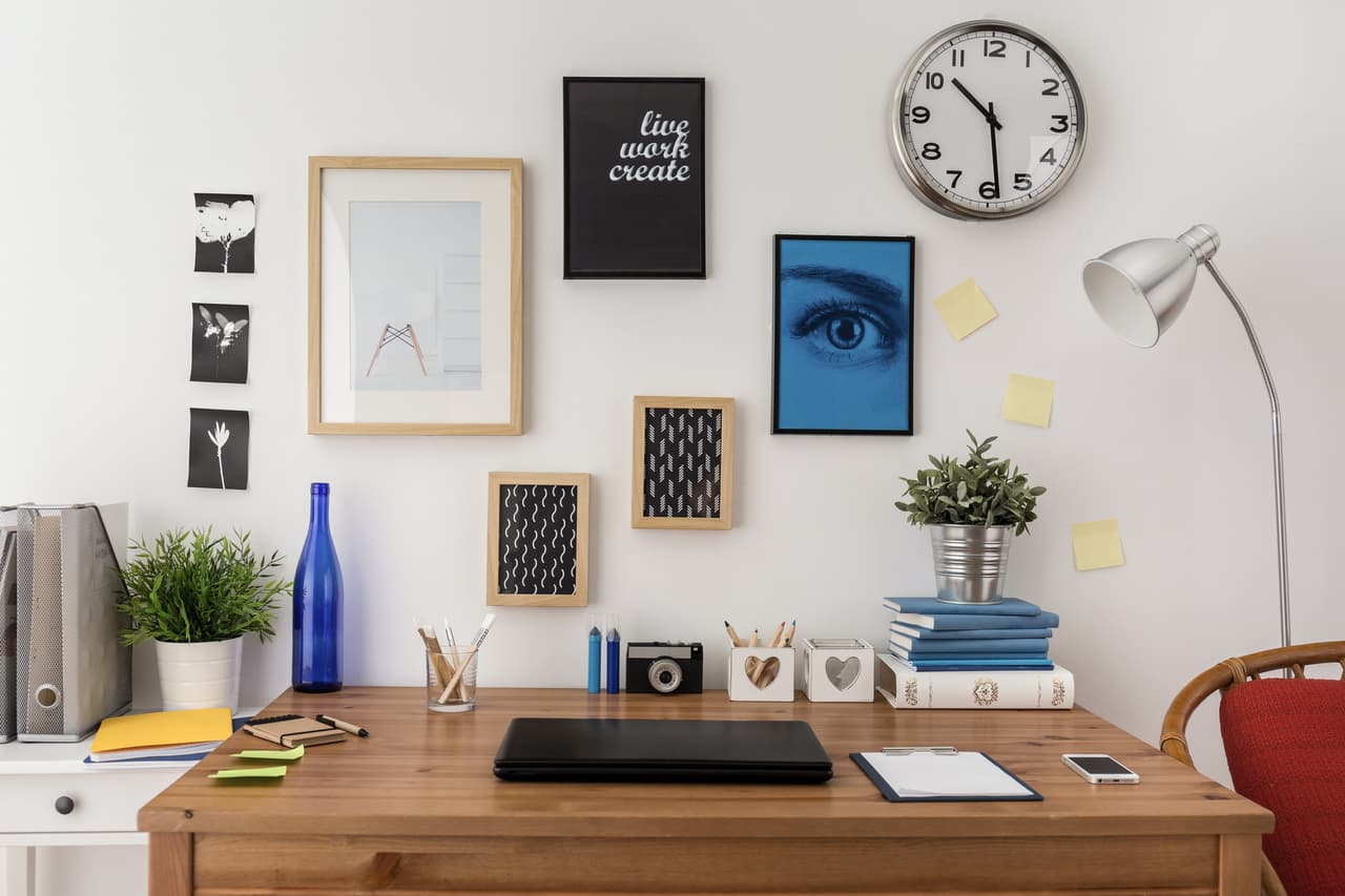 Decoraciones que alegren tu escritorio. Puedes incluir fotos, cuadros, plantas, ilustraciones, entre otros objetos.