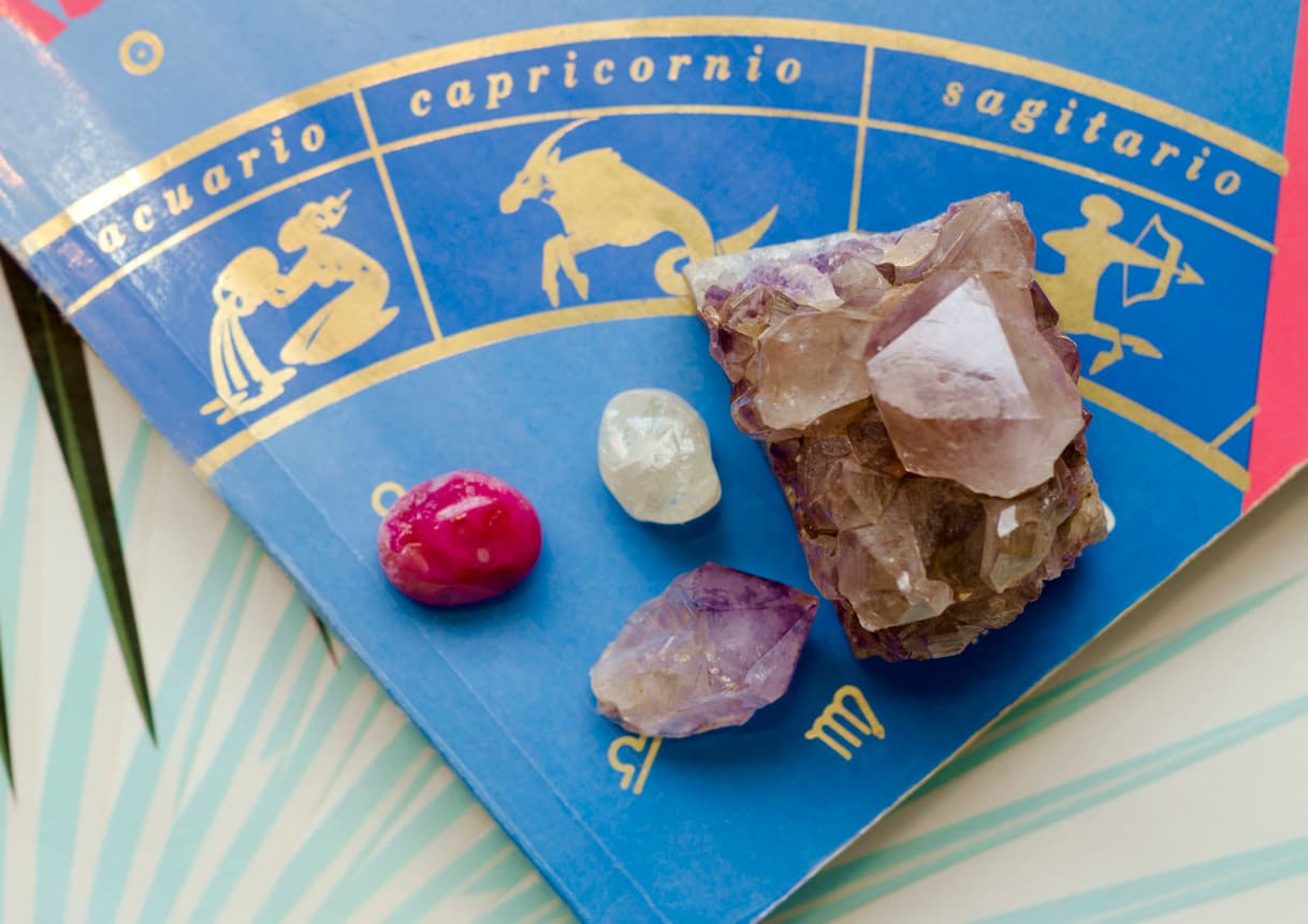 A book with astrology signs in his cover , and some crystals