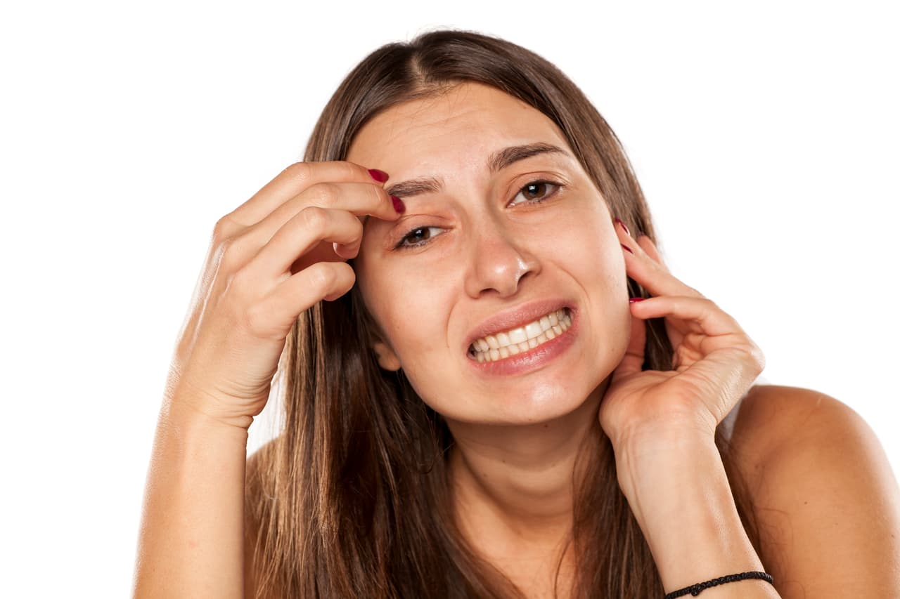 nervous young woman has an itch in eyebrows