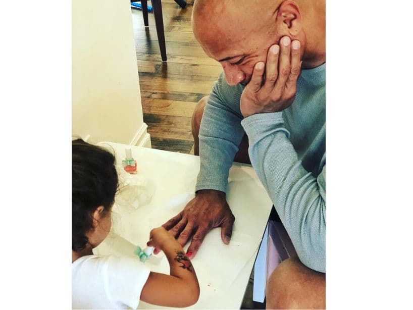 La Roca se deja pintar las uñas por su pequeña hija, Jasmine.