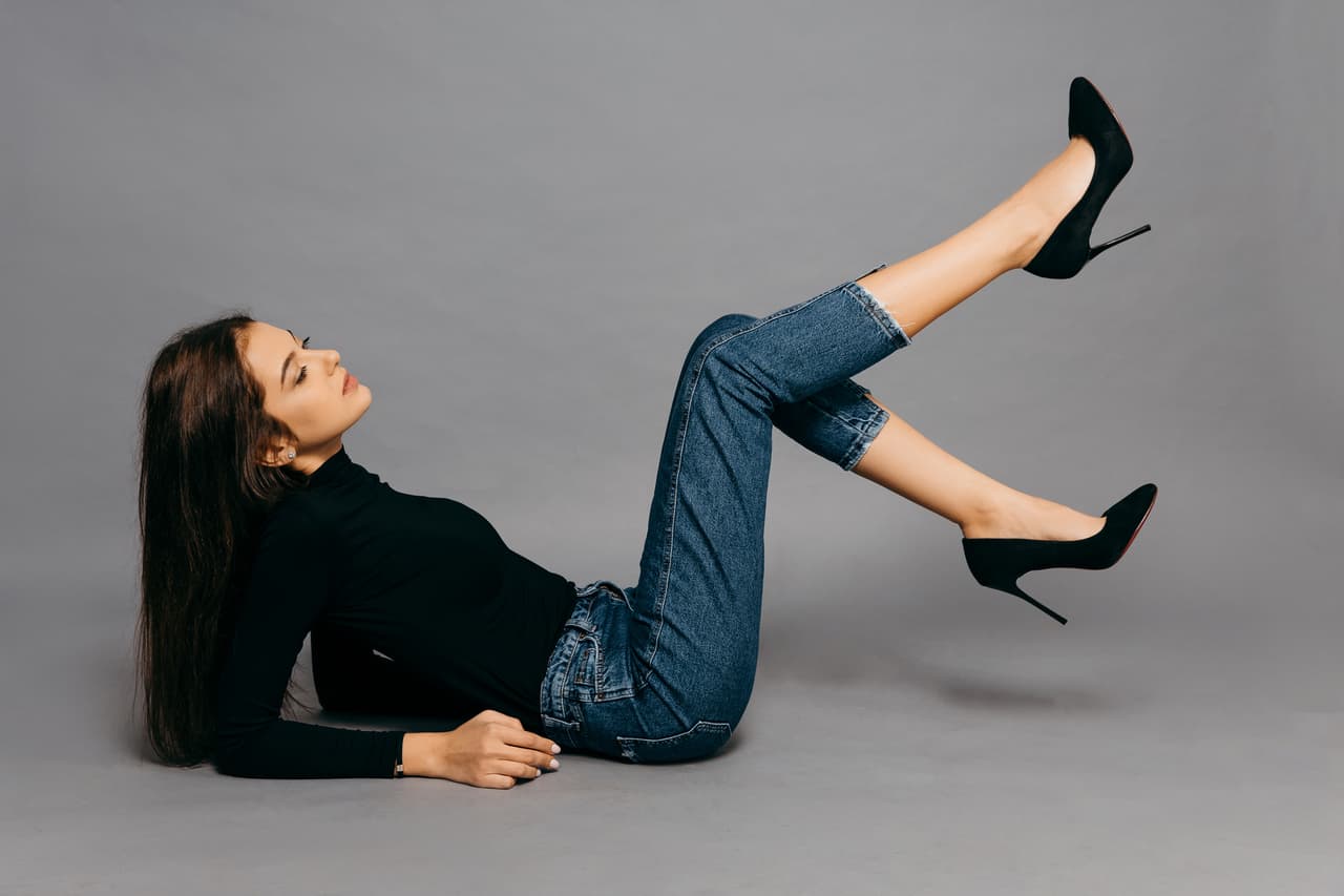 young woman lying on the floor isolated on gray background. High quality photo