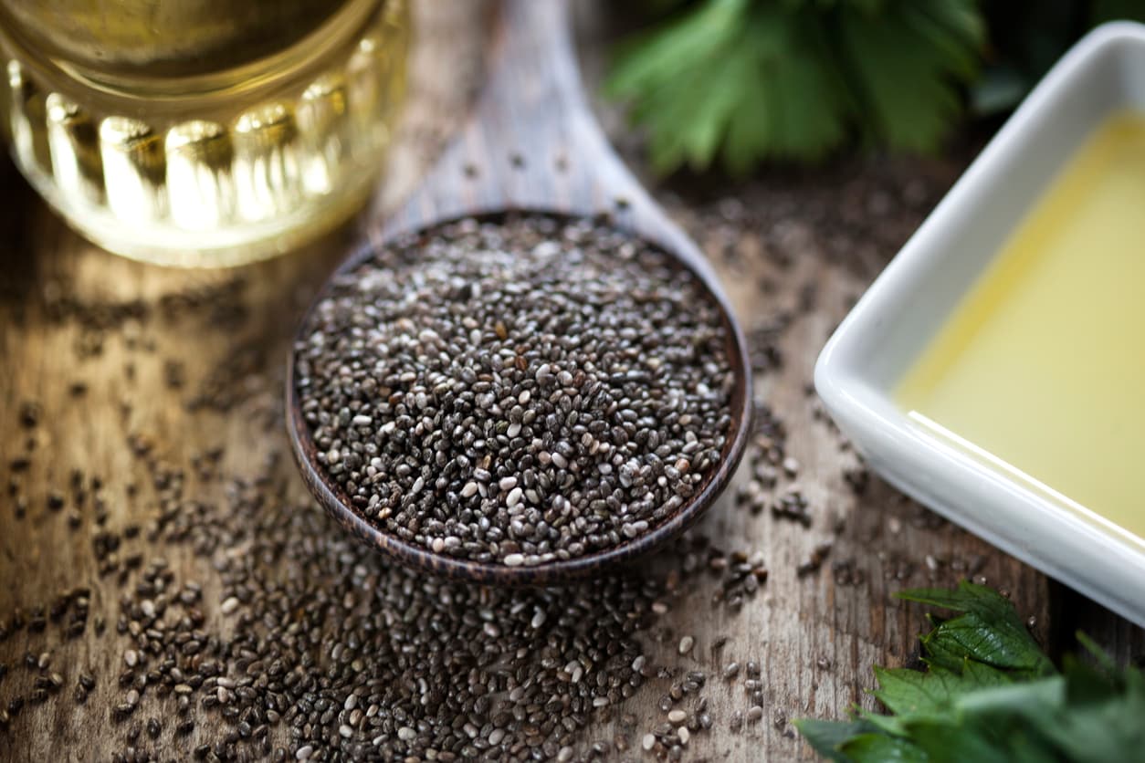 Wooden spoon with chia seeds (salvia hispanica) and oil
