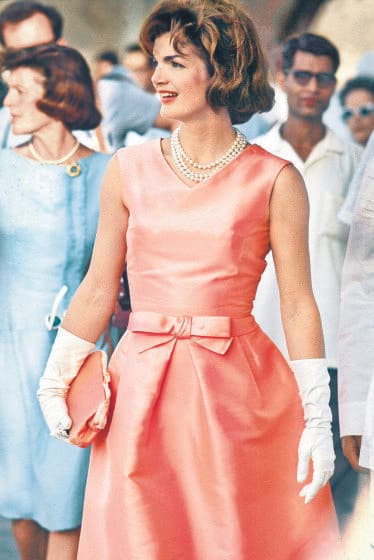 La historia de Oscar de la Renta con el guardaropa de las primeras damas de Estados Unidos comenzó con Jackie Kennedy luego de que vistiera una de las piezas del diseñador dominicano en 1962 para un viaje a la India. Se trataba de un elegante vestido con largo midi en color melocotón y con un lazo a la cintura.