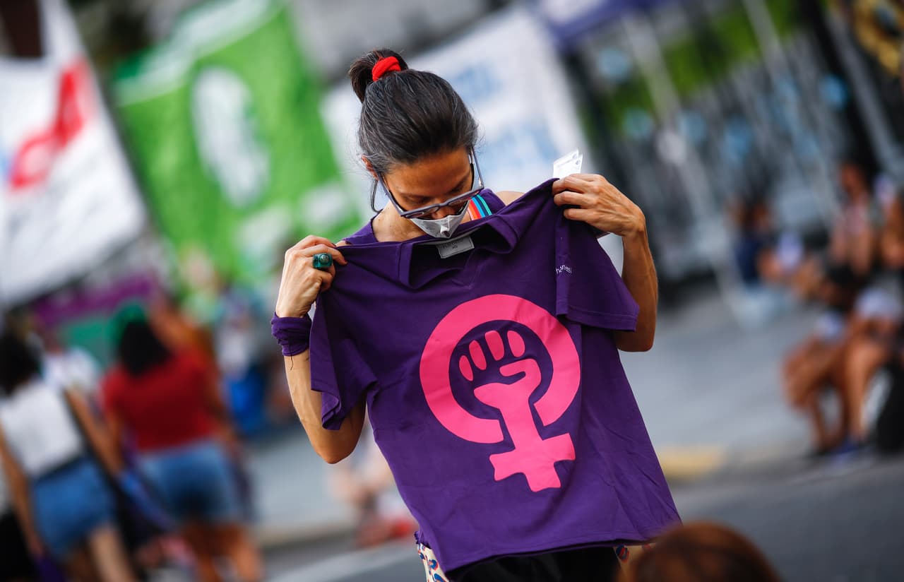 BUENOS AIRES, ARGENTINA - MARCH 08: A woman holds a t-shirt with a feminist symbol as she takes part in a demonstration to mark the International Women's Day outside the Congress on March 8, 2021 in Buenos Aires, Argentina. This year the main demand is to stop the femicides and transvesticides, after 50 have been officially registered in the first two months of 2021. (Photo by Marcos Brindicci/Getty Images)