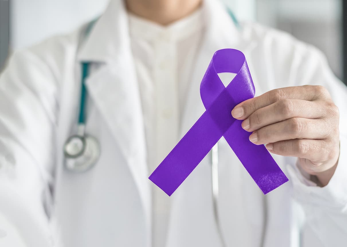 Purple violet ribbon symbolic bow color on doctor's hand support for Hodgkin's lymphoma and testicular cancer awareness