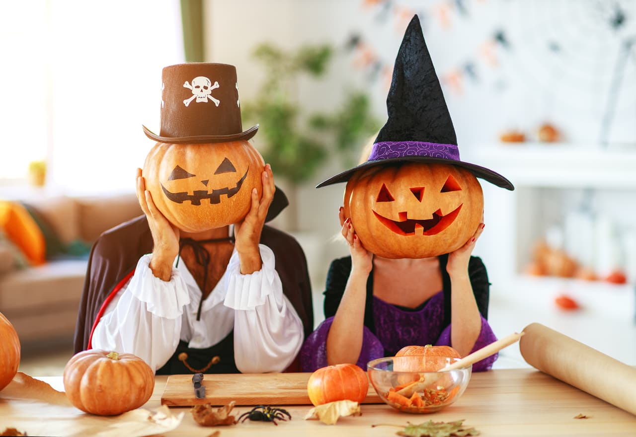 Halloween concept. a couple of people dressed as witches and vampires with pumpkins for heads