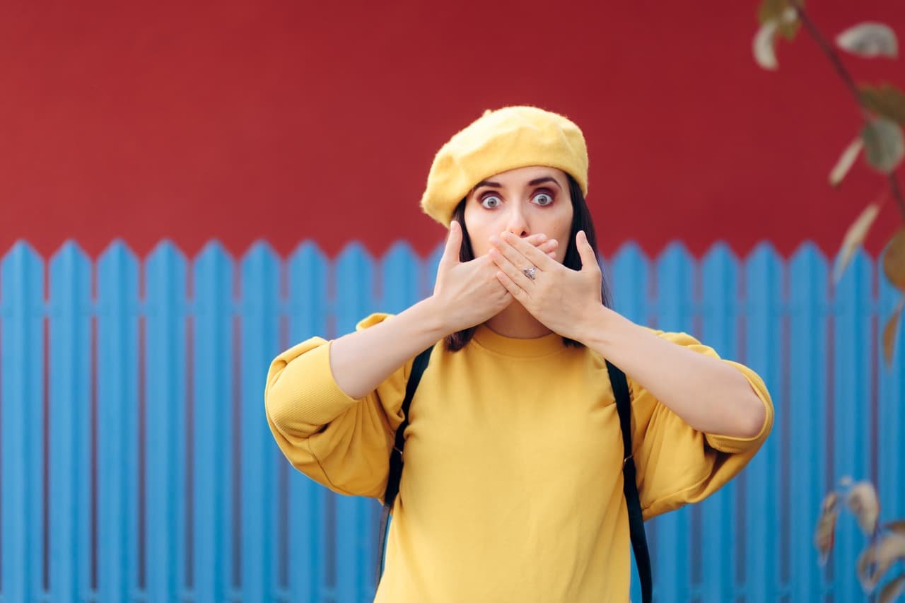 Polite girl hiding hiccup with hands gesture