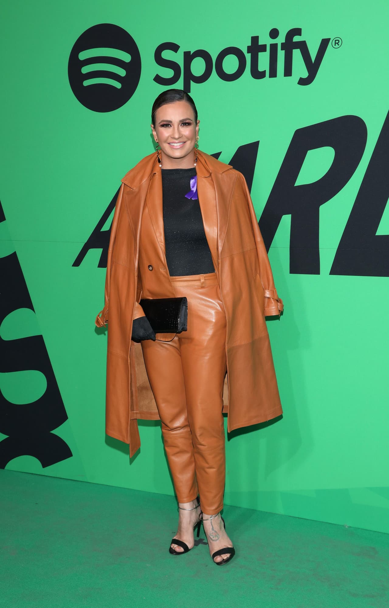 La cantante María José usó un look completo en vinipiel en color camel, pero se dejó ver con una insignias color morado, lo que se especuló era en favor de las iniciativas de movimientos feministas, en vísperas del Día de la Mujer.