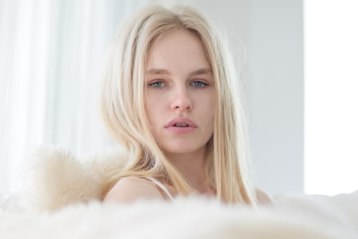 Close-up of gorgeous young caucasian woman looking at the camera while sitting at home.