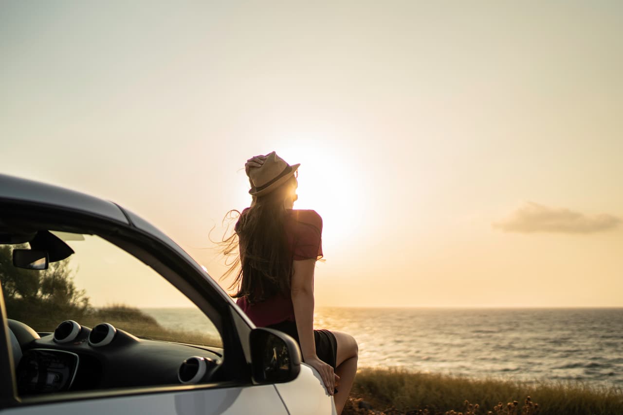 Rear view of a woman sitting in a car looking at view