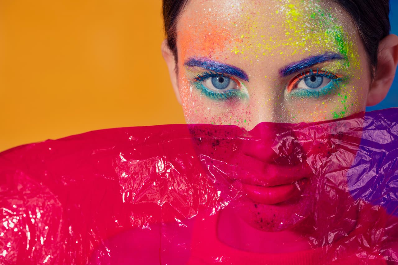 Fashion woman makeup with pink gel veil hiding her face with a cellophane veil