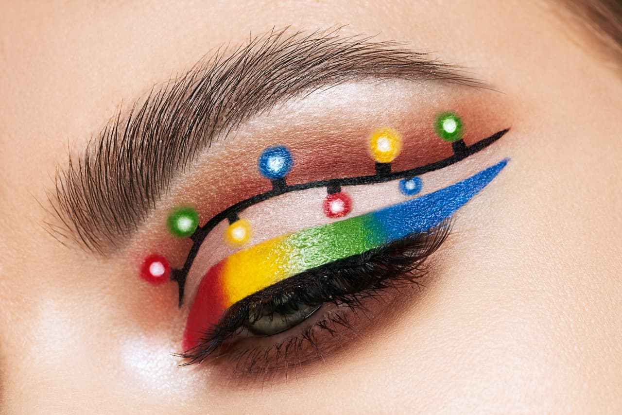 Eye of a girl with makeup Christmas lights. Winter christmas makeup. Beauty fashion. Eyelashes. Creative New Year's holiday makeup close-up