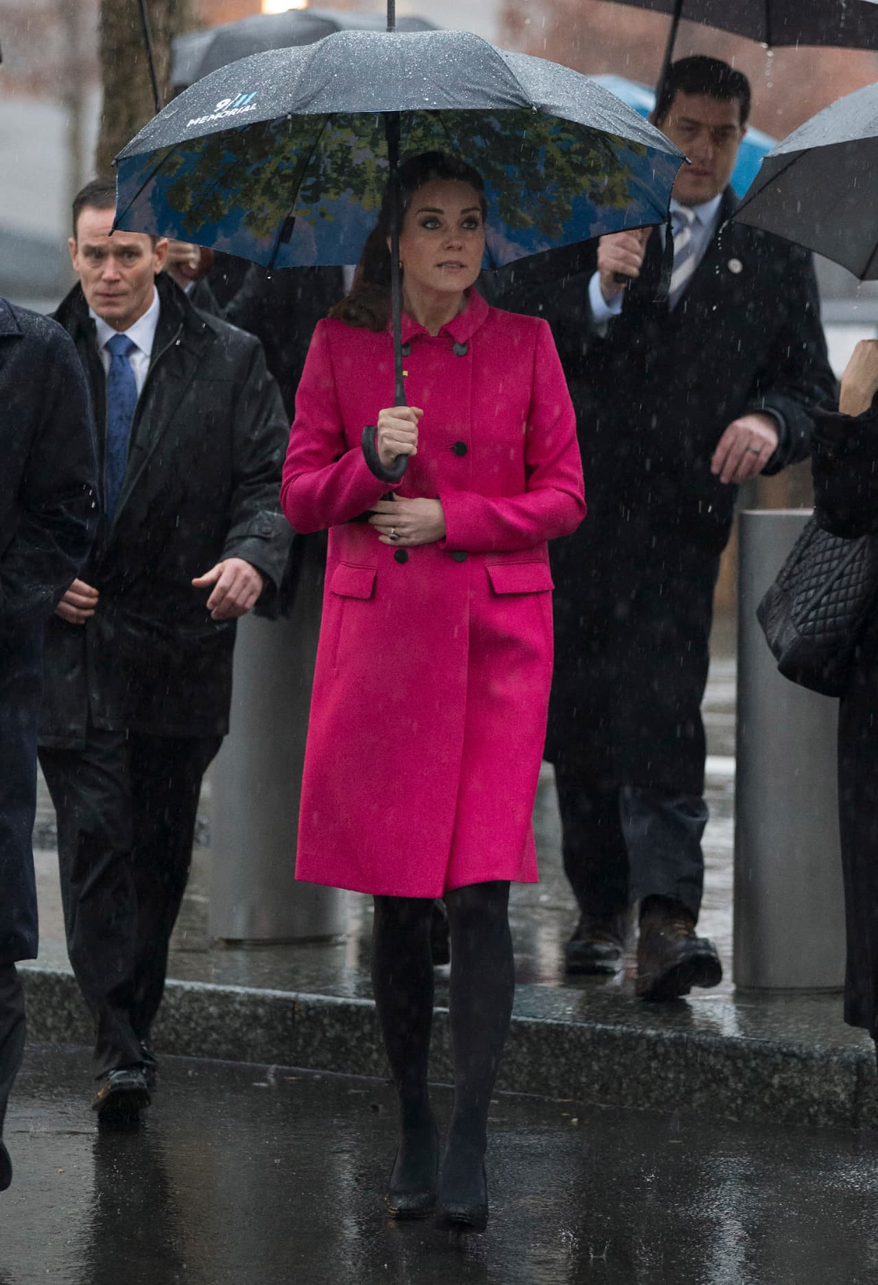 2014 - Porque ni el clima lluvioso de Nueva York fue motivo para que la duquesa perdiera el estilo, Kate nos deleitó con este sencillo e impactante look en el que el gran acierto fue el color de su abrigo, un rosa mexicano que resaltó su tez blanca y su cabello oscuro, y que contrastó con unas mallas y tacones negros.