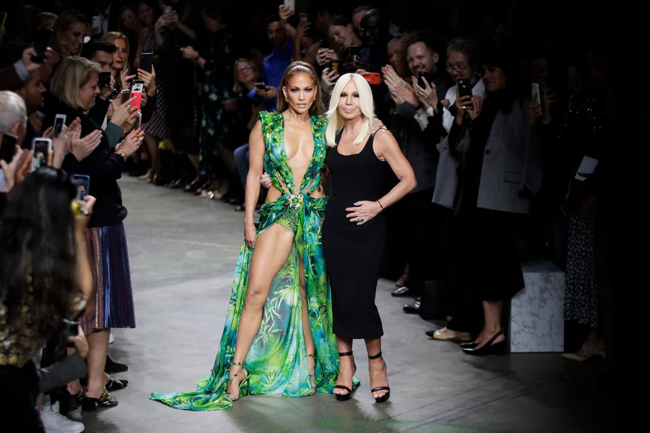 Actress Jennifer Lopez, left, and designer Donatella Versace accept applause at the conclusion of the Versace Spring-Summer 2020 collection, unveiled during the fashion week, in Milan, Italy, Friday, Sept. 20, 2019. (AP Photo/Luca Bruno)