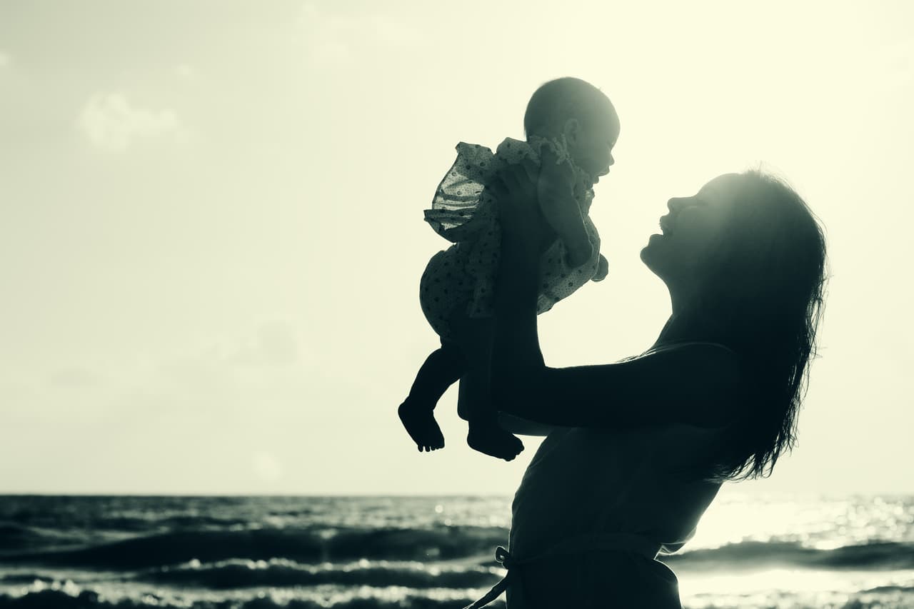 portrait of young mother and her cute baby on the seaside