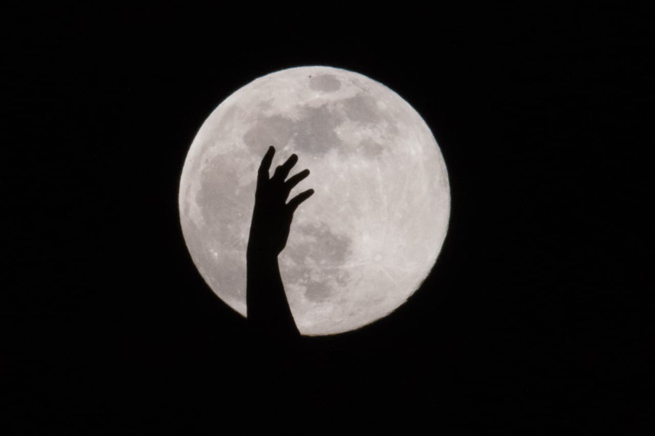 VIENNA, AUSTRIA - APRIL 07: Supermoon appears in the distance behind a silhouette of a statue on top of the Burgtheater on April 07, 2020 in Vienna, Austria. A supermoon occurs when the moon reaches its closest position to the Earth, known as the perigee, making the satellite appear bigger and brighter than usual. This month’s supermoon is also a Pink Moon, so-called by the Native Americans because of the pink flowers that appeared in the east of North America at this time of year. (Photo by Thomas Kronsteiner/Getty Images)