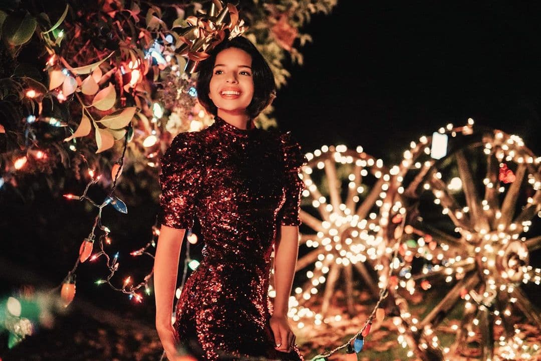 Ángela Aguilar también se unió a la tendencia de telas brillantes y hombros con volumen, pues para su look de fiestas decembrinas lució un deslumbrante vestido con lentejuelas en color vino.
