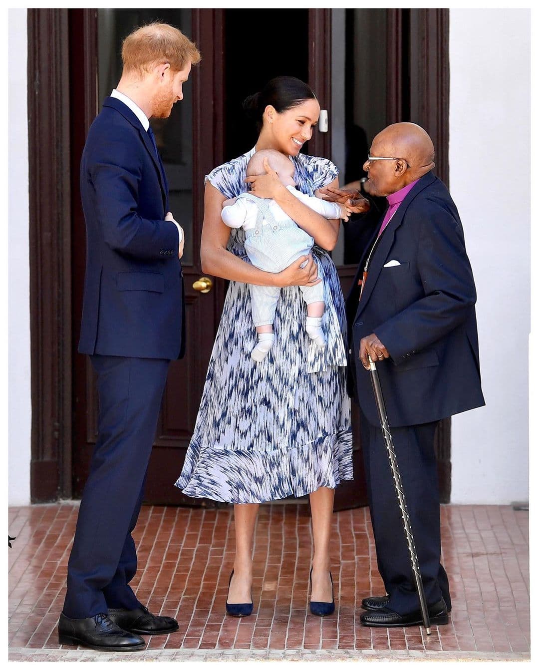 En un viaje que realizó la pareja a Sudáfrica, Meghan usó un vestido estampado de Club Monaco en tono azul, que combinó con el overol de su bebé, Archie.