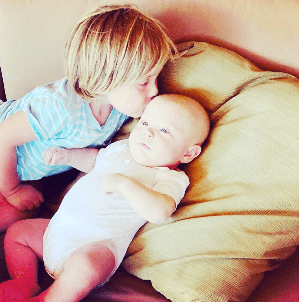 Manu, de 3 años de edad, el primogénito de la pareja, dándole besitos a su hermanito cuando cumplió cuatro meses de nacido.