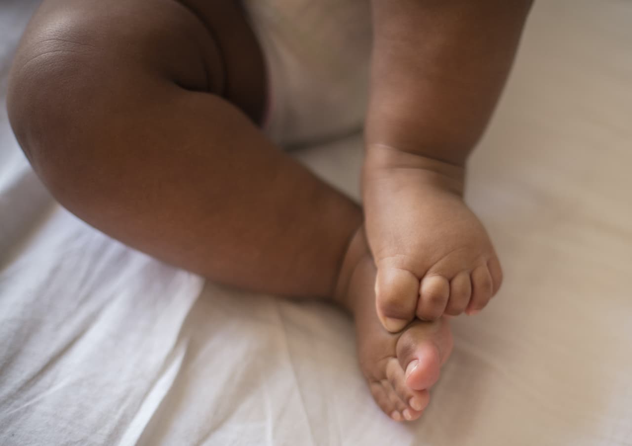 Tiny toes. Little baby on bed.